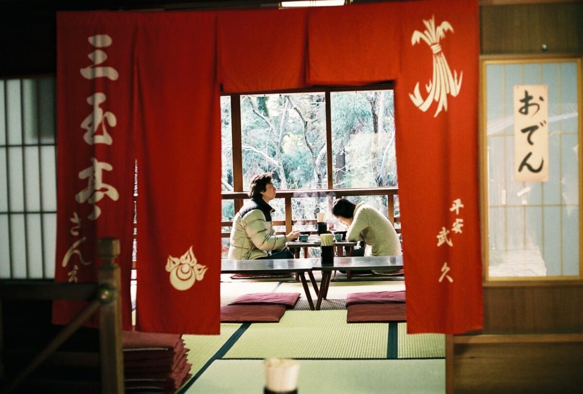 A serene scene inside a traditional Japanese tea house in Nara, Japan. Two people enjoying a meal.